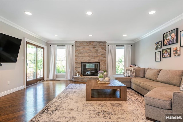 living room featuring crown molding, recessed lighting, wood finished floors, and a fireplace