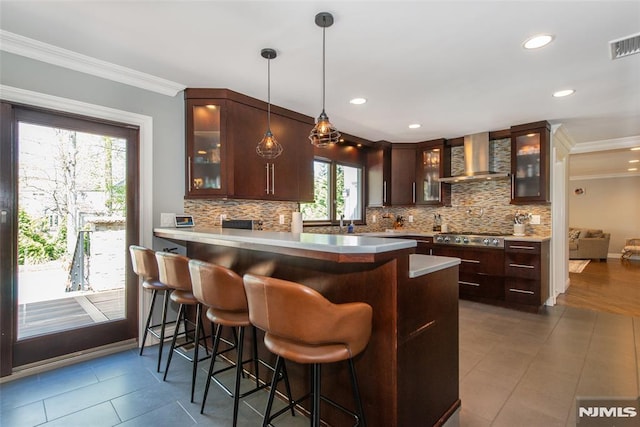 kitchen featuring crown molding, decorative backsplash, and wall chimney exhaust hood
