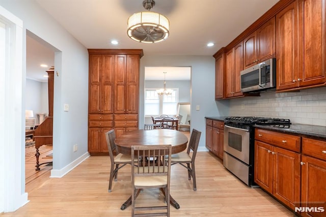 kitchen with backsplash, a chandelier, stainless steel appliances, recessed lighting, and light wood-style flooring