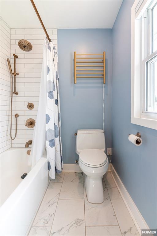 bathroom with toilet, baseboards, marble finish floor, and shower / tub combo with curtain