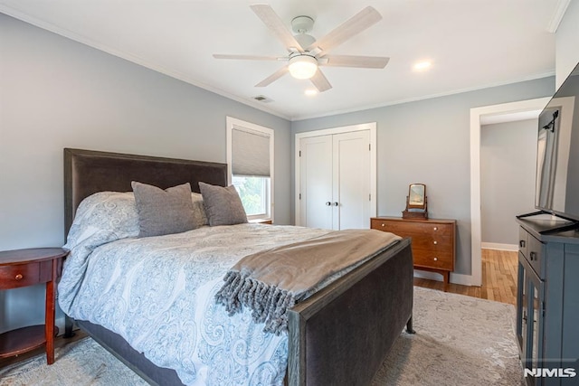 bedroom featuring crown molding, baseboards, light wood finished floors, and visible vents