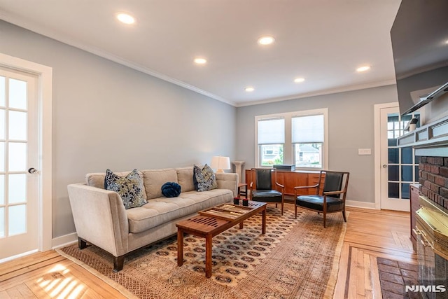 living room with baseboards, ornamental molding, a brick fireplace, and recessed lighting