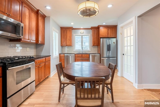 kitchen featuring a sink, decorative backsplash, appliances with stainless steel finishes, and dark countertops