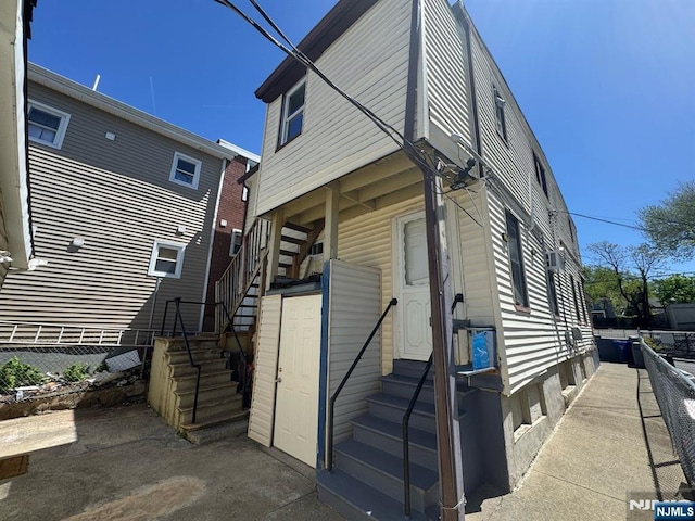 view of front of property featuring entry steps, fence, and stairs