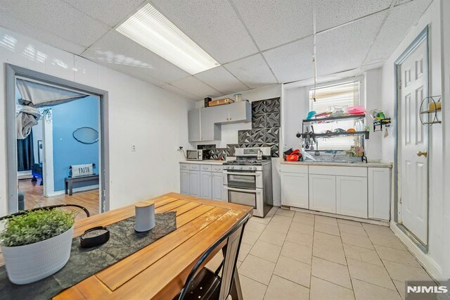 41 Heckel St, Belleville, NJ 07109 - kitchen featuring light countertops, appliances with stainless steel finishes, a drop ceiling, and a sink