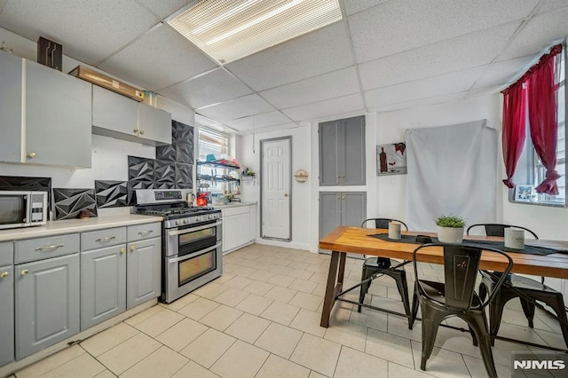 41 Heckel St, Belleville, NJ 07109 - kitchen featuring a paneled ceiling, gray cabinetry, light countertops, light tile patterned floors, and stainless steel appliances