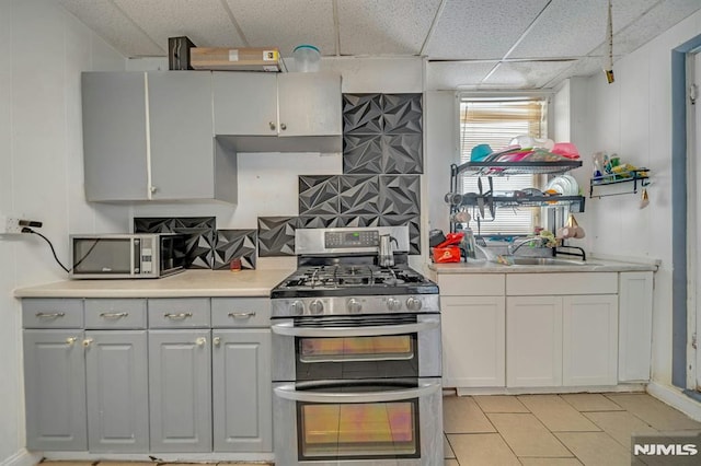 41 Heckel St, Belleville, NJ 07109 - kitchen featuring a drop ceiling, a sink, light countertops, light tile patterned floors, and stainless steel appliances