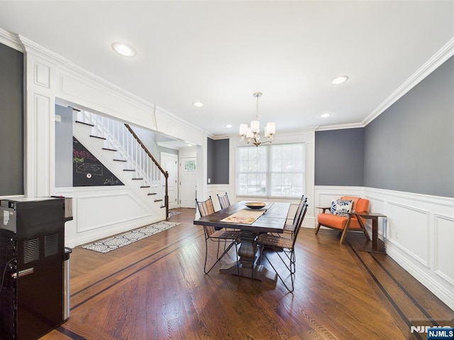 dining space with crown molding, an inviting chandelier, stairway, and a decorative wall