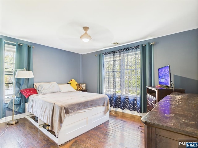 bedroom with ceiling fan, wood-type flooring, and visible vents
