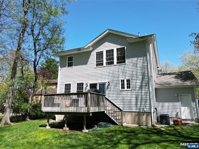 rear view of house featuring central air condition unit, a deck, and a lawn
