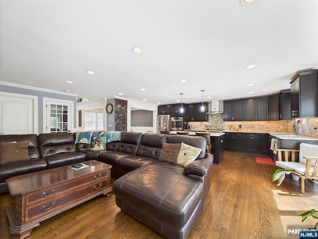 living area with crown molding, recessed lighting, and dark wood-type flooring