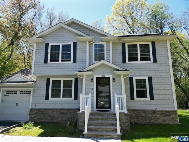 view of front of house featuring an attached garage and stone siding
