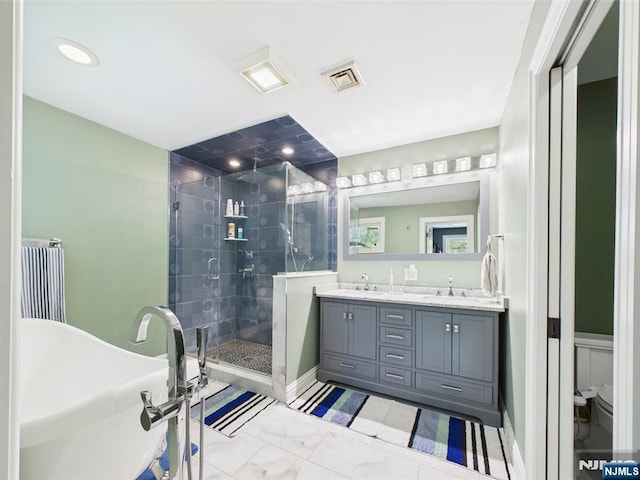 bathroom with double vanity, visible vents, a freestanding tub, a shower stall, and a sink