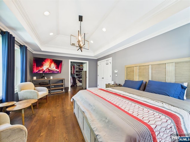 bedroom featuring crown molding, an inviting chandelier, recessed lighting, dark wood-type flooring, and a tray ceiling