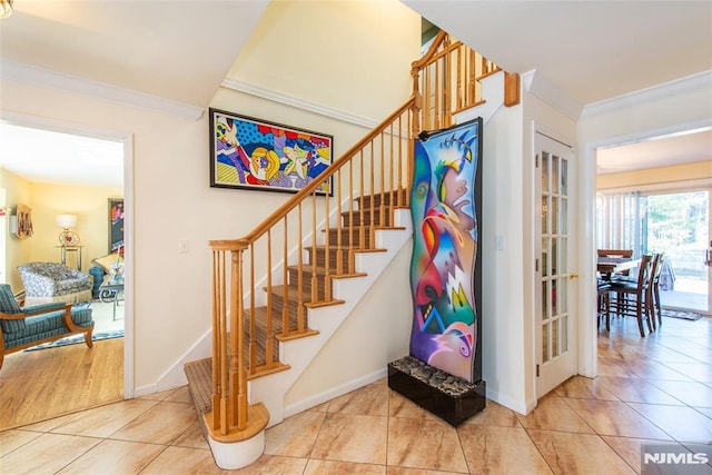 stairs with baseboards, ornamental molding, and tile patterned flooring