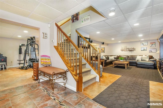 interior space with recessed lighting, baseboards, a paneled ceiling, and stairs