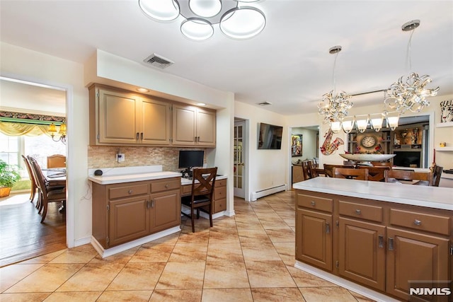 kitchen with an inviting chandelier, light countertops, a baseboard radiator, and visible vents