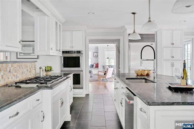 kitchen with a sink, white cabinetry, appliances with stainless steel finishes, and a healthy amount of sunlight