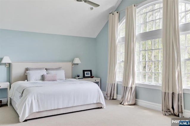 bedroom with carpet floors, multiple windows, and lofted ceiling