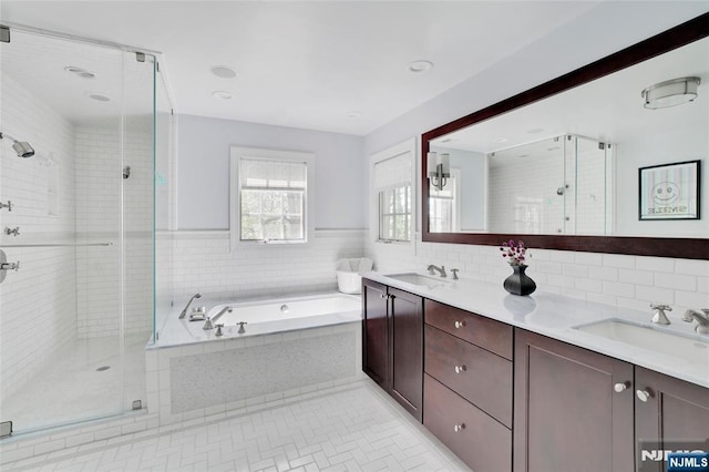 bathroom with a sink, a stall shower, and a bath