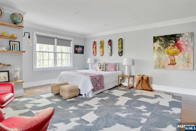 bedroom featuring crown molding, baseboards, and wood finished floors