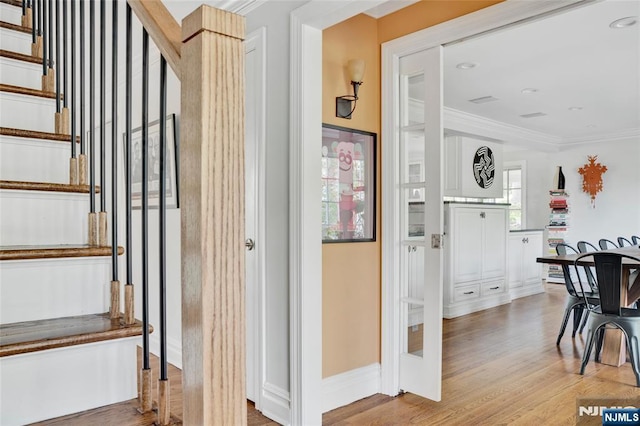 staircase featuring baseboards, ornamental molding, and wood finished floors