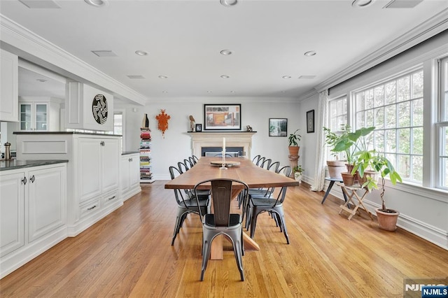 dining space featuring recessed lighting, baseboards, light wood finished floors, and a fireplace