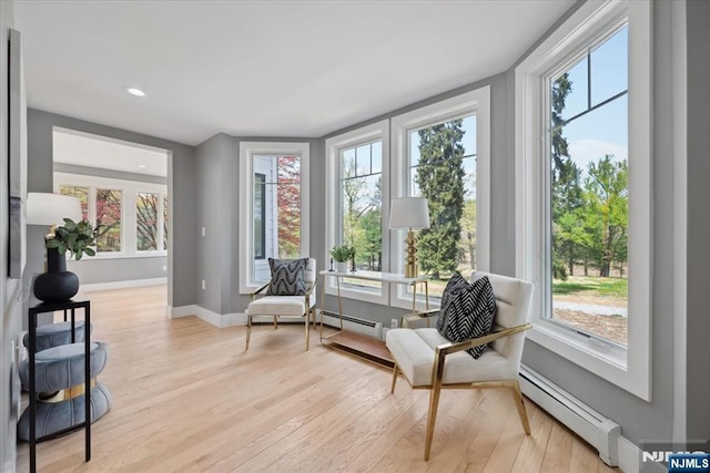 sitting room with light wood-type flooring, recessed lighting, baseboards, and baseboard heating