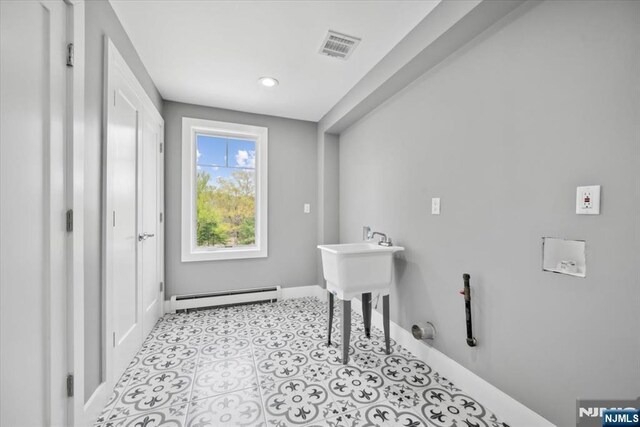 bathroom with baseboards, a baseboard heating unit, and visible vents
