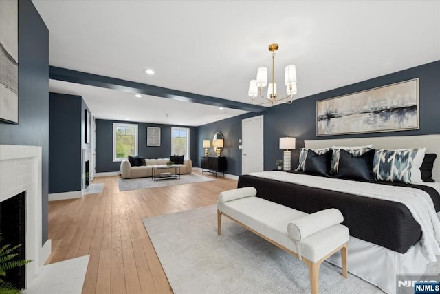 bedroom with an inviting chandelier, a brick fireplace, baseboards, recessed lighting, and light wood-style flooring