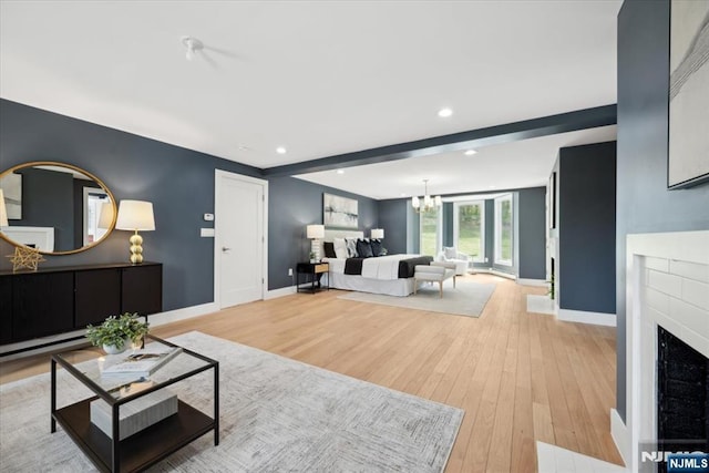 living room featuring an inviting chandelier, recessed lighting, light wood-style floors, and baseboards