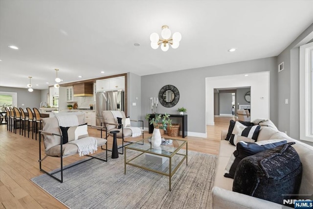 living room with recessed lighting, an inviting chandelier, light wood finished floors, and visible vents