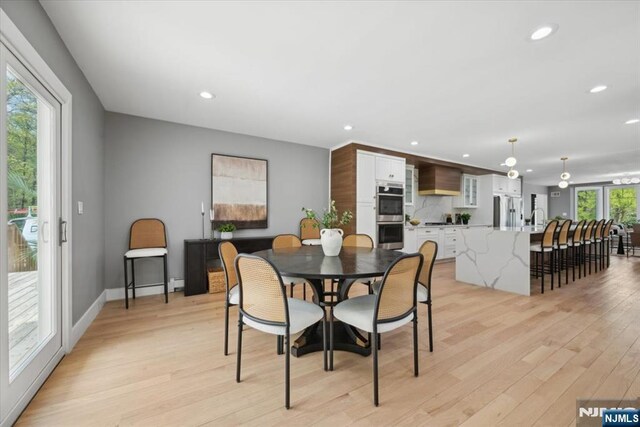 dining space featuring recessed lighting, light wood finished floors, and baseboards