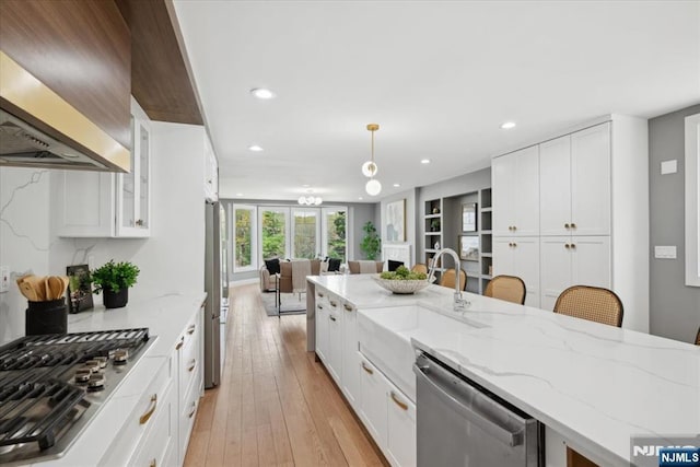 kitchen with recessed lighting, a sink, appliances with stainless steel finishes, and open floor plan