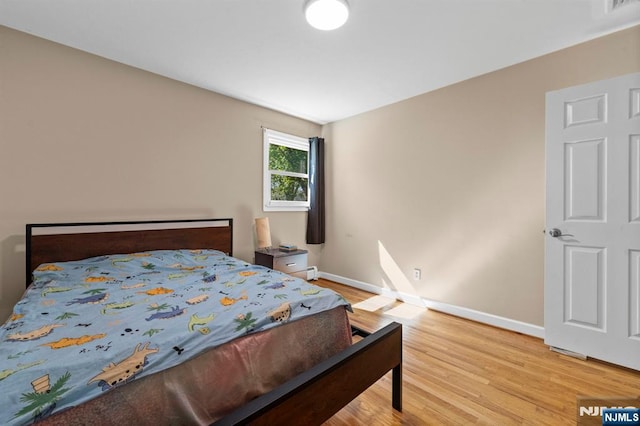bedroom featuring baseboards and light wood-style flooring