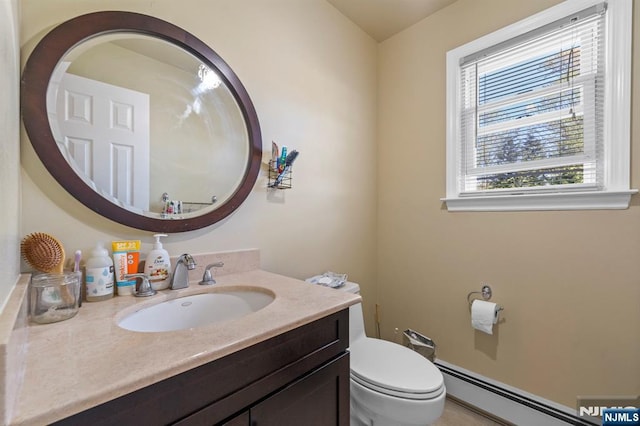bathroom featuring toilet, baseboard heating, and vanity