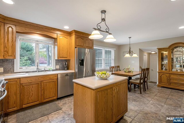 kitchen with light countertops, a sink, backsplash, and stainless steel appliances