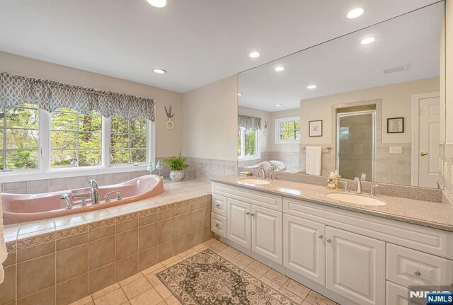 full bath featuring recessed lighting, a sink, tile patterned floors, and a shower stall
