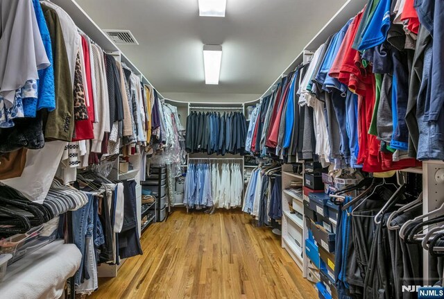 walk in closet with visible vents and wood finished floors