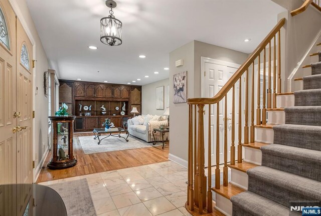 foyer entrance featuring baseboards, recessed lighting, stairs, and light wood-type flooring