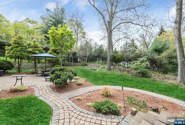 surrounding community with a lawn, fence, and a patio area