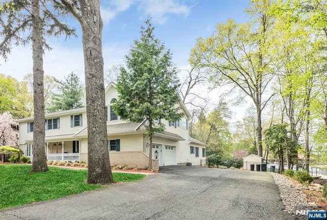view of front of home with brick siding, a front lawn, and driveway
