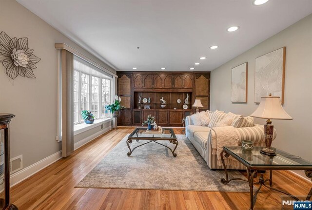 living area featuring recessed lighting, baseboards, and light wood-style flooring