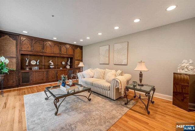 living area with recessed lighting, baseboards, and light wood-type flooring