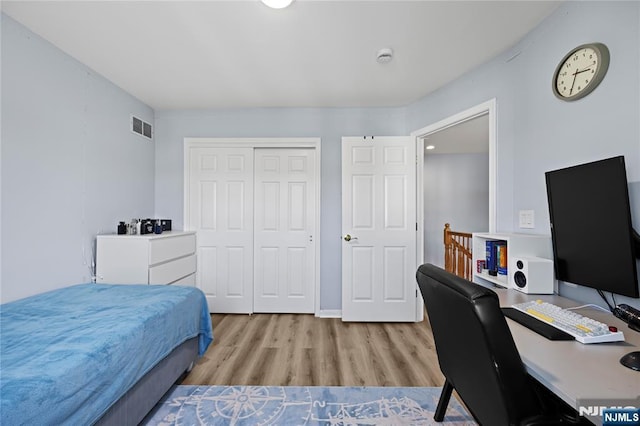 bedroom featuring a closet, wood finished floors, and visible vents