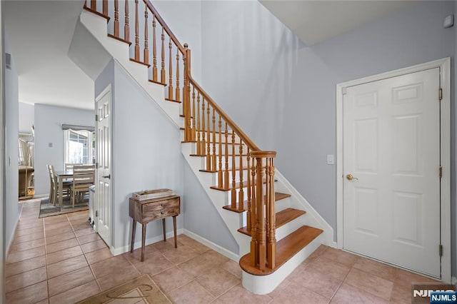 stairs featuring tile patterned floors and baseboards