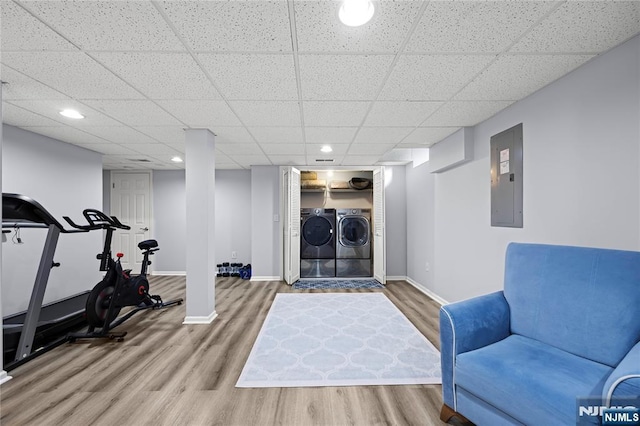 exercise room featuring baseboards, electric panel, and wood finished floors