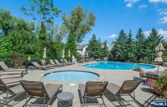 pool with a patio and fence
