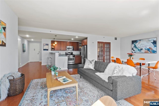 living room featuring french doors, recessed lighting, baseboards, and wood finished floors