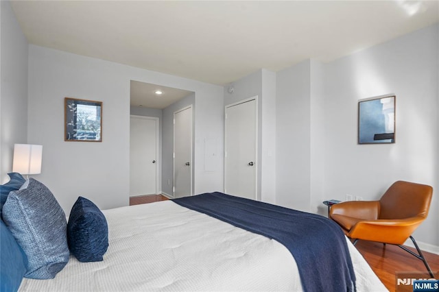 bedroom featuring recessed lighting, baseboards, wood finished floors, and a closet